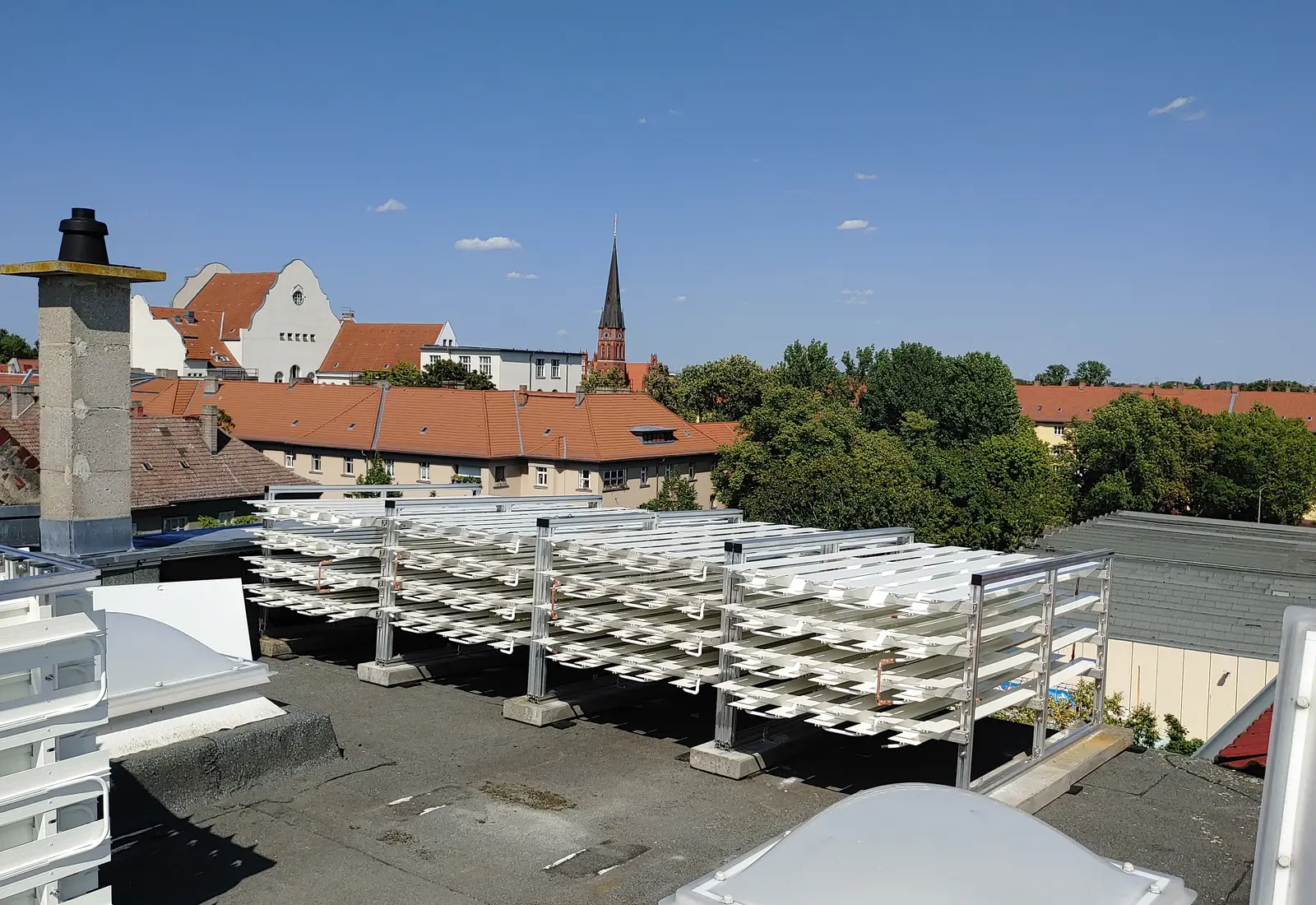 Installierte weiße ThermalGain Dachabsorber auf einem Berliner Mehrfamilienhaus